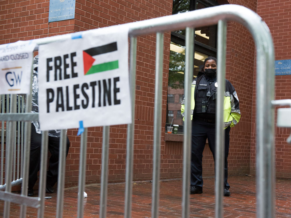 A George Washington University Police officer stands watch inside the school's University Yard as students protest the Israel-Hamas war in Washington Saturday.