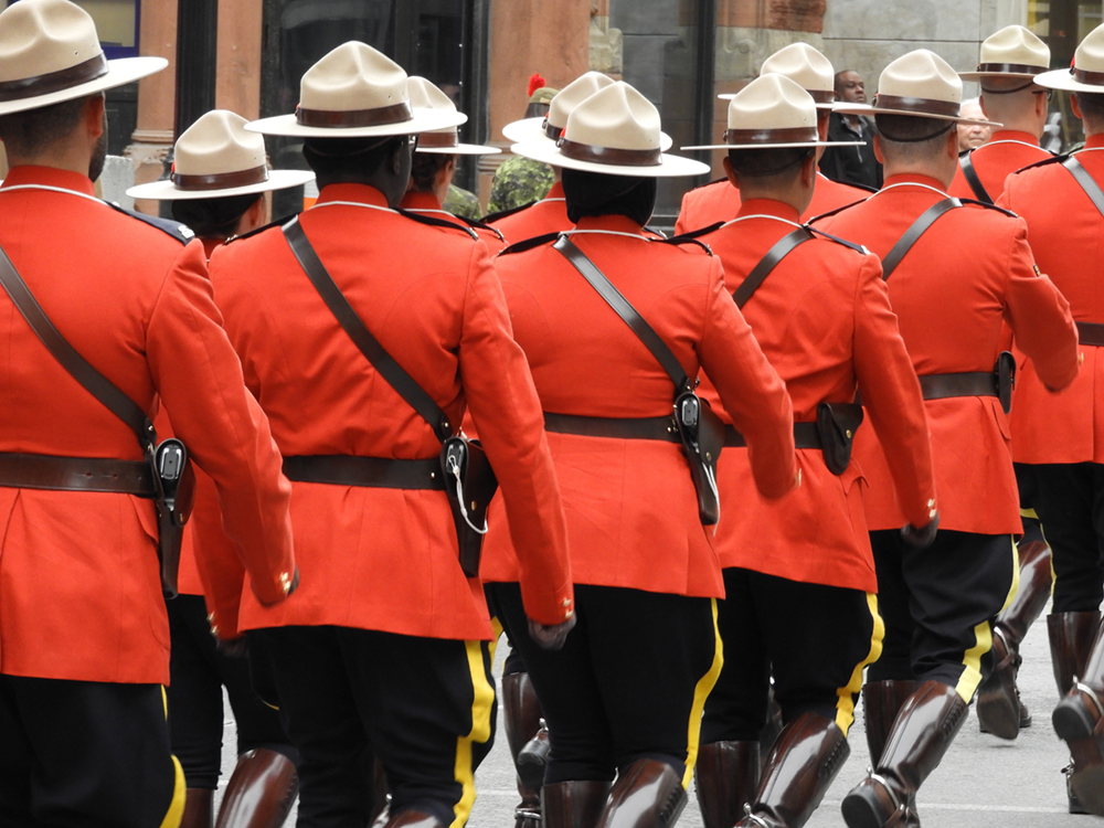 RCMP in red uniforms, walking away.